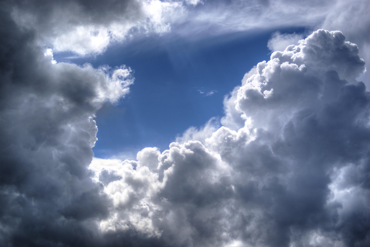 Cielo azul casi cubierto por nubes blancas y en tonos grises