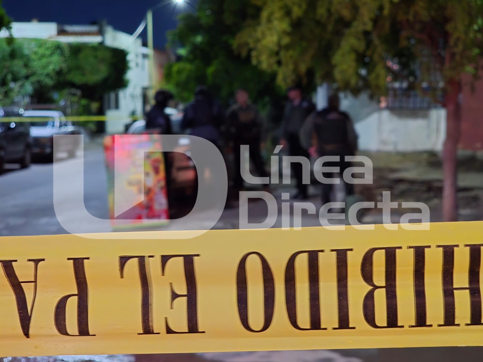 Cinta amarilla de precaución y al fondo elementos policiacos