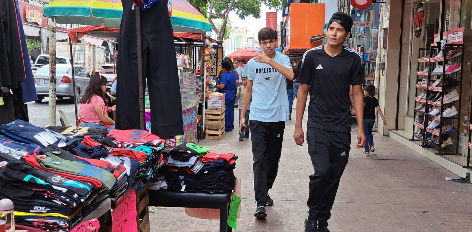 Comercio de ropa en Culiacán junto a dos jóvenes sobre la banqueta