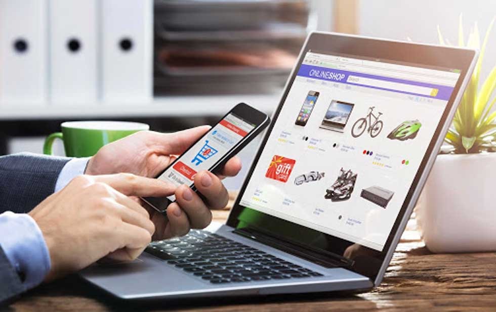 Persona con un celular y una laptop