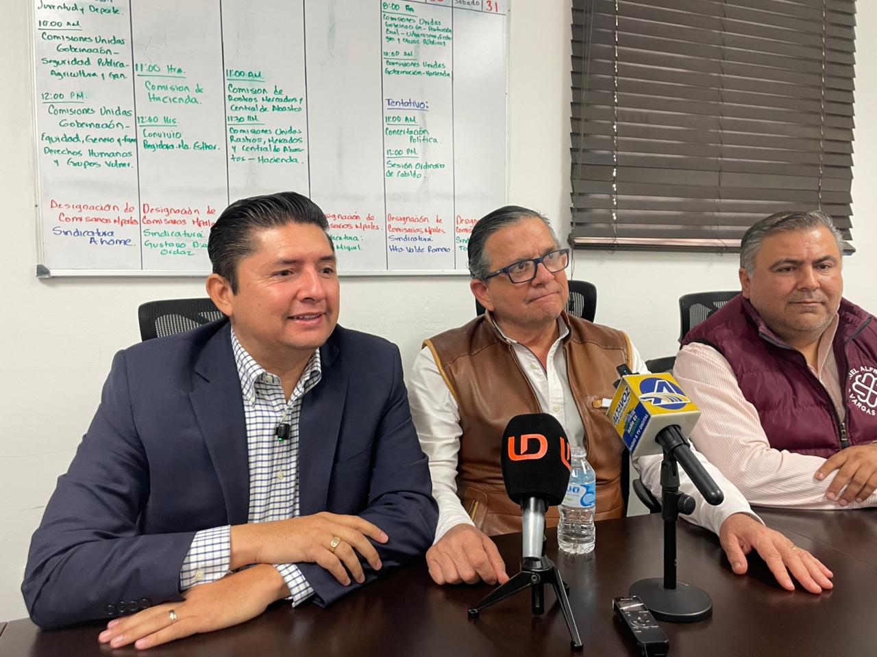 Personas sentadas con micrófonos enfrente
