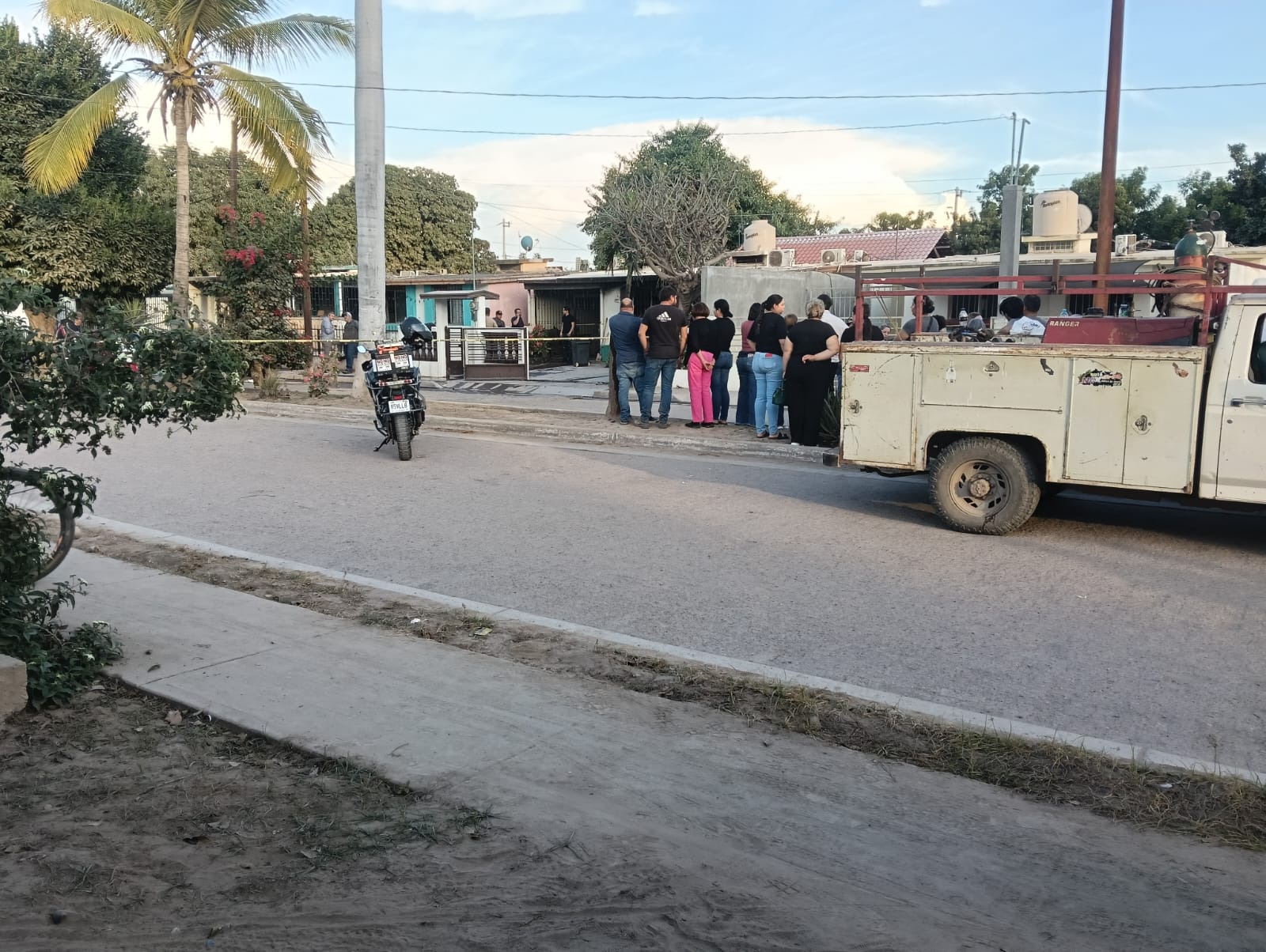 Vecinos reunidos afuera del domicilio de la adulta mayor.