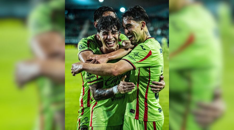 Jugadores de futbol abrazandose en un estadio
