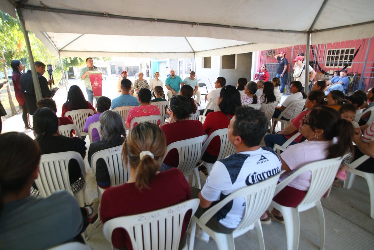 Personas sentadas debajo de una carpa en entrega de calle pavimentada