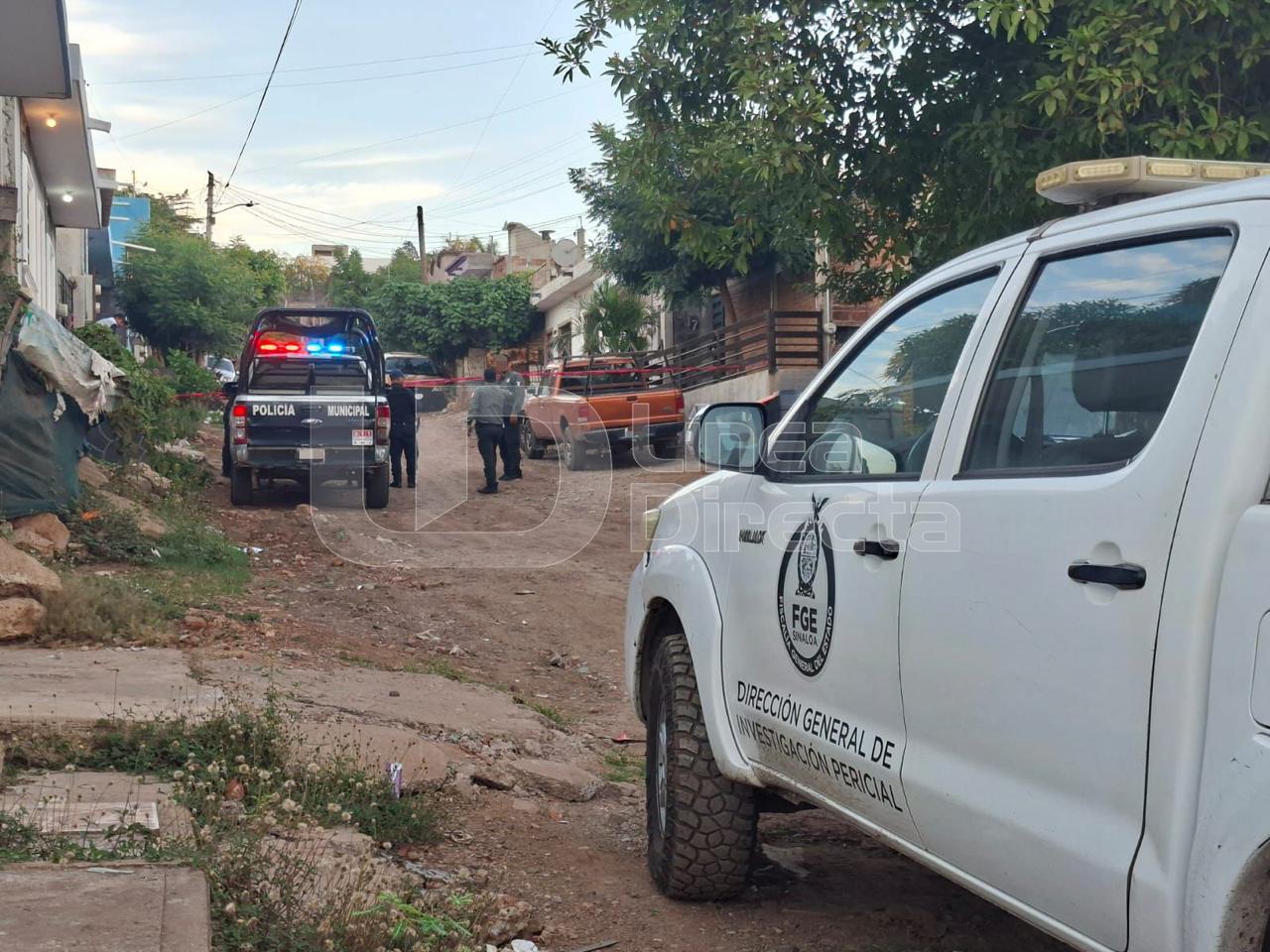 Unidad de la FGE y policia municipal en una calle de terracería entre casas