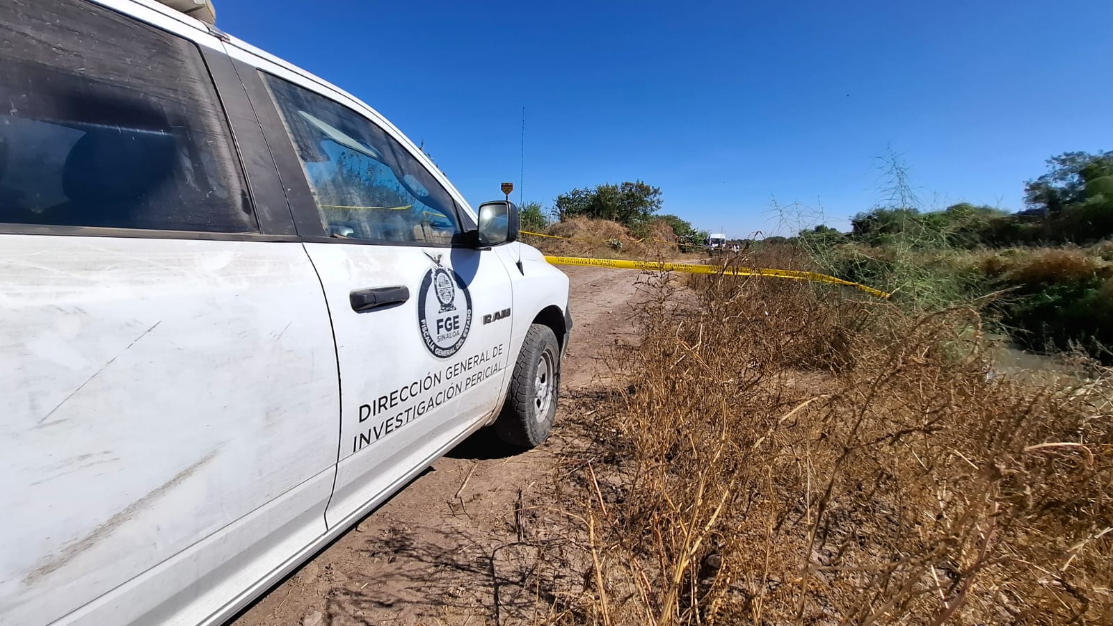 Unidad de la FGE frente a una cinta amarilla de precaución en un dren
