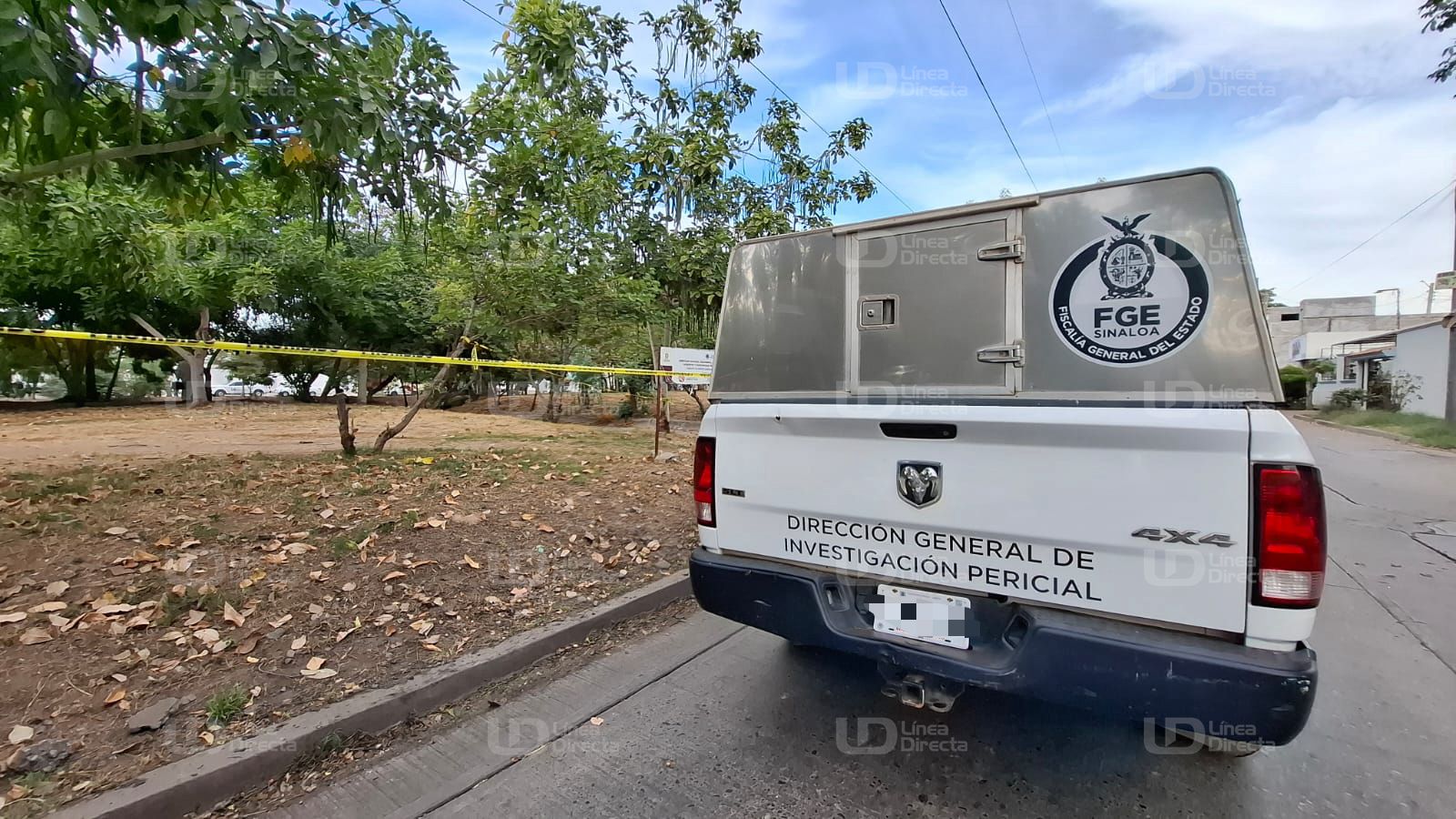 Unidad de la FGE en una calle y se observa una cinta amarilla de precaución