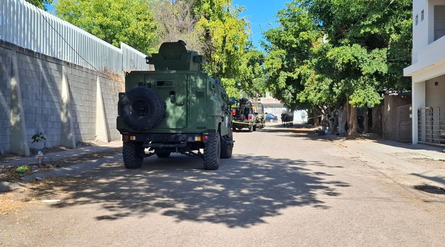 Unidades del Ejército Mexicano y patrullas municipales en una calle de terracería junto a una cinta amarilla de precaución