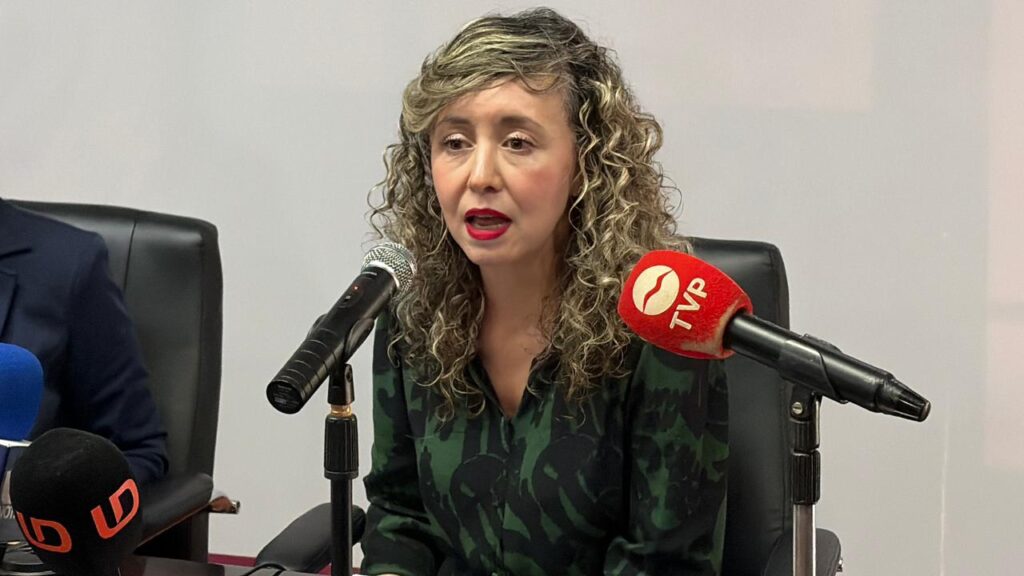 Mujer hablando con micrófonos frente a ella