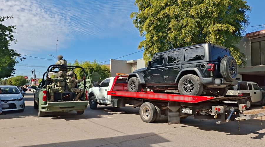Unidad del Ejército y una Jeep arriba de una grúa