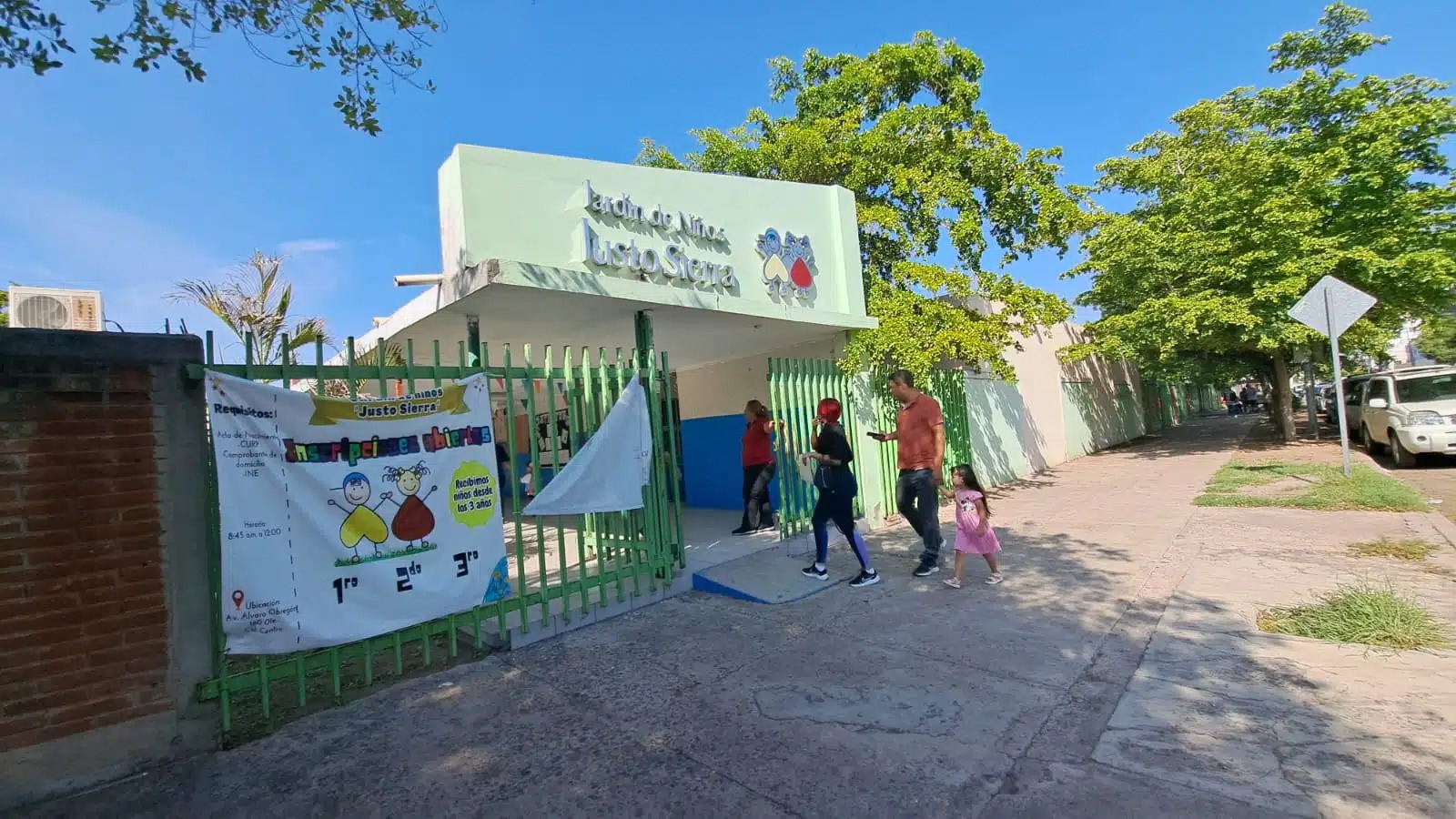 Puerta principal de kinder y padres de familia y estudiante accediendo