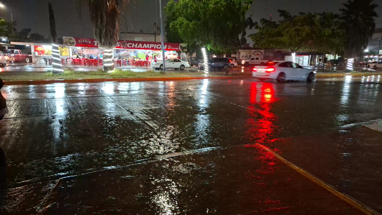 Carros en una calle mojada por la lluvia