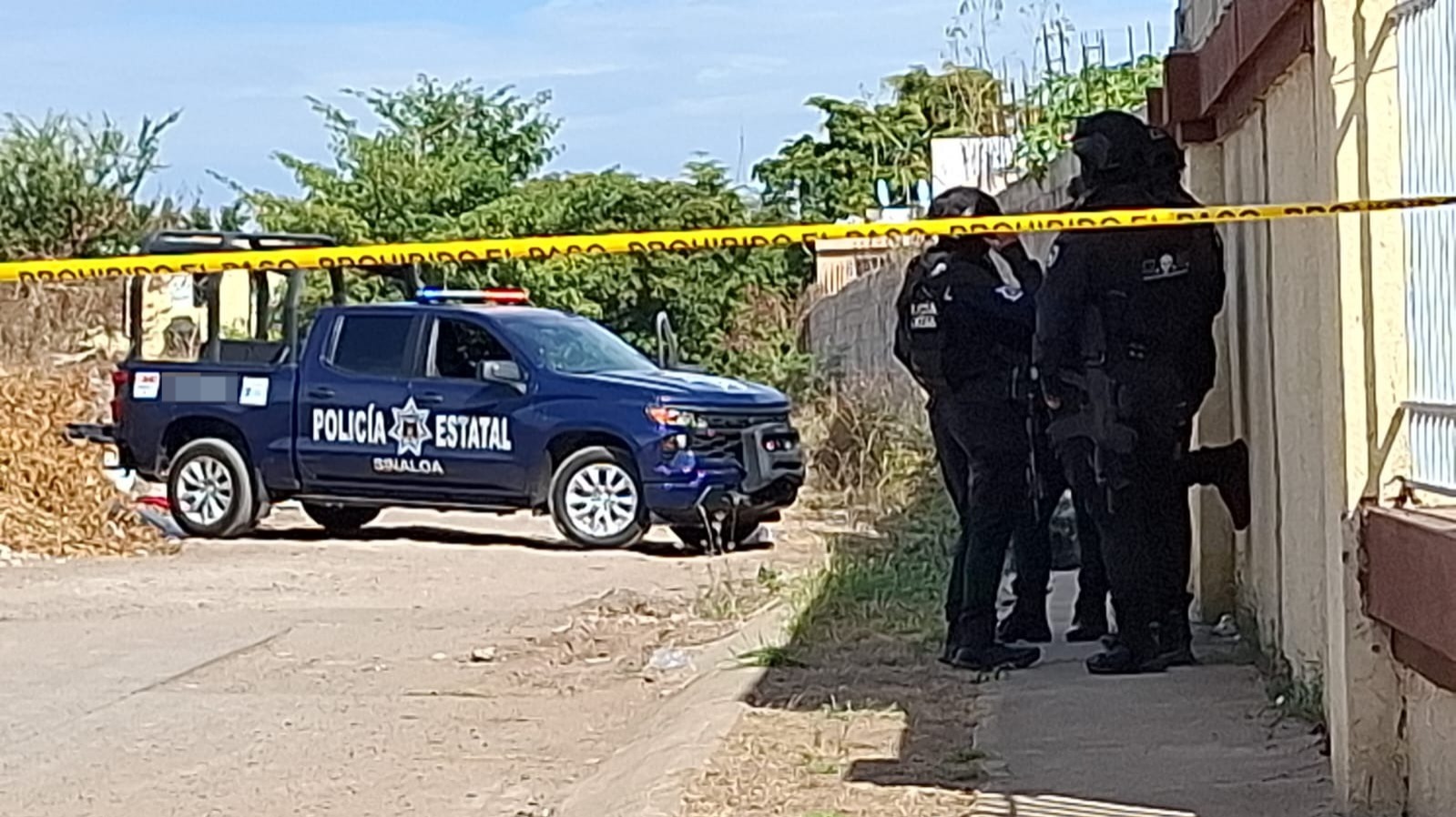 Unidades de seguridad parados en la acera en una zona acordonada y una patrulla de fondo