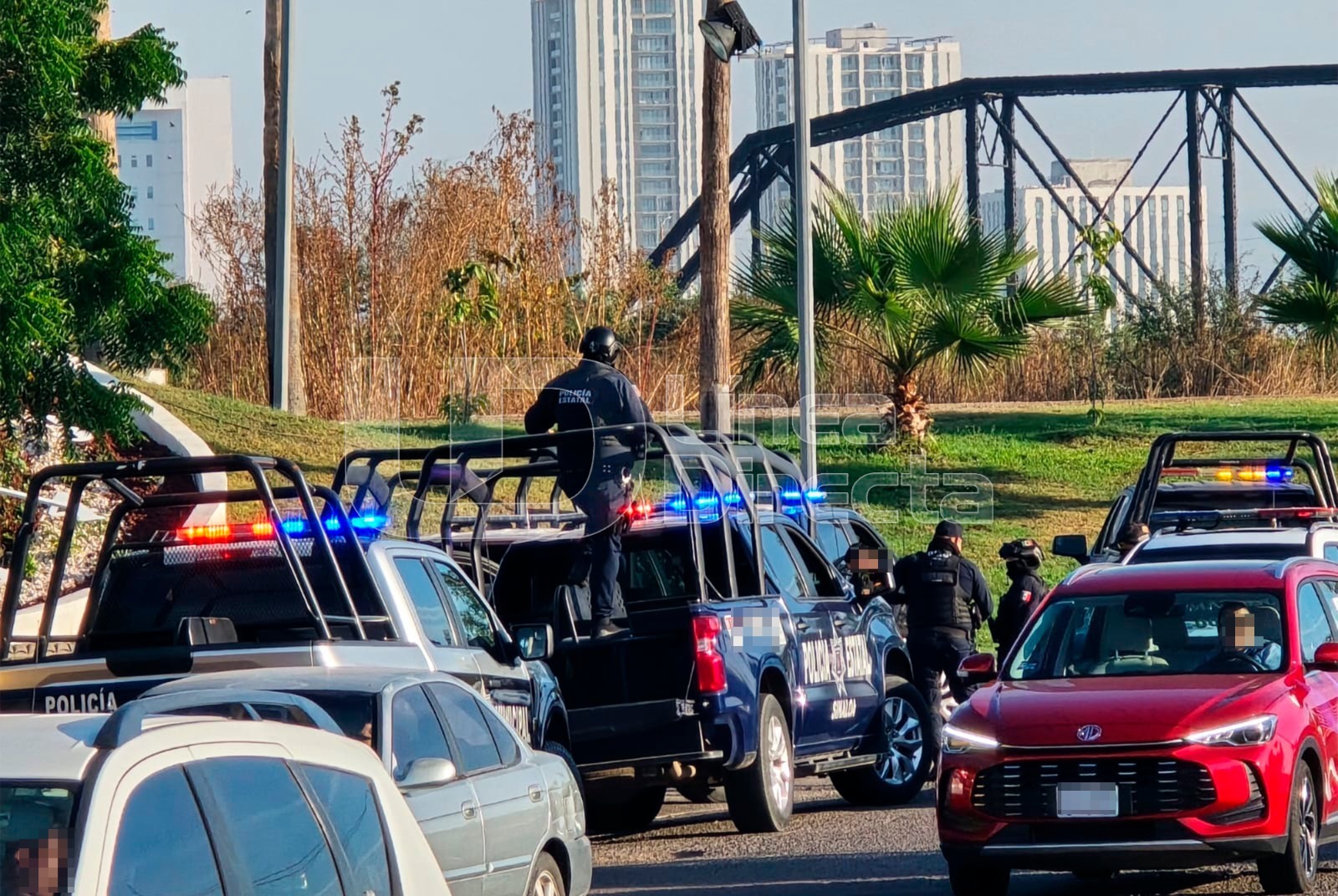 Unidad de policía municipal con elementos arriba de la unidad en vialidad