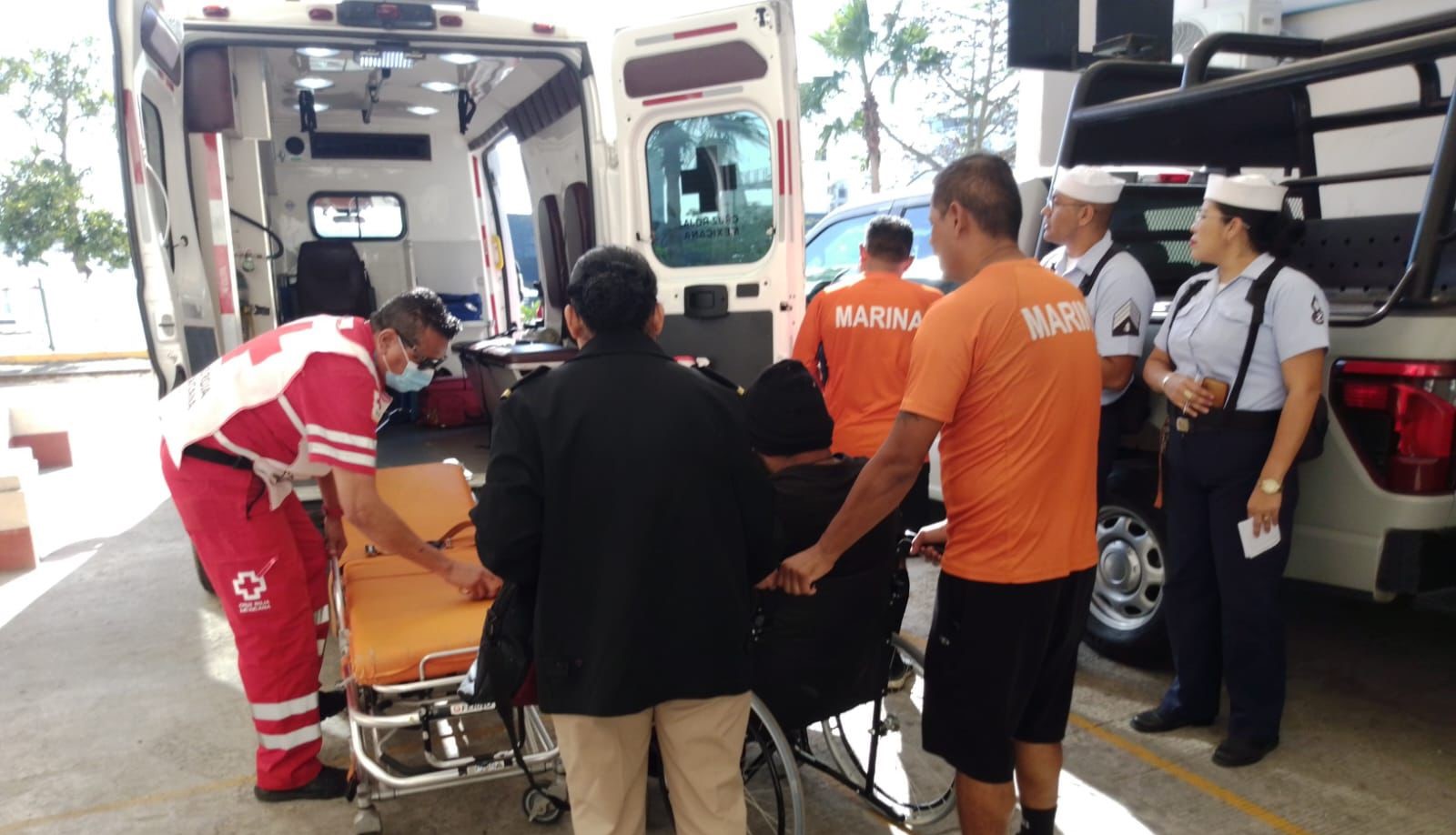 Personal de la cruz roja llevando a una persona a la ambulancia