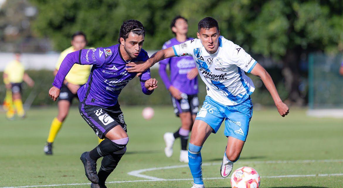 Jugador del Mazatlán FC peleando junto a uno del Puebla el balón