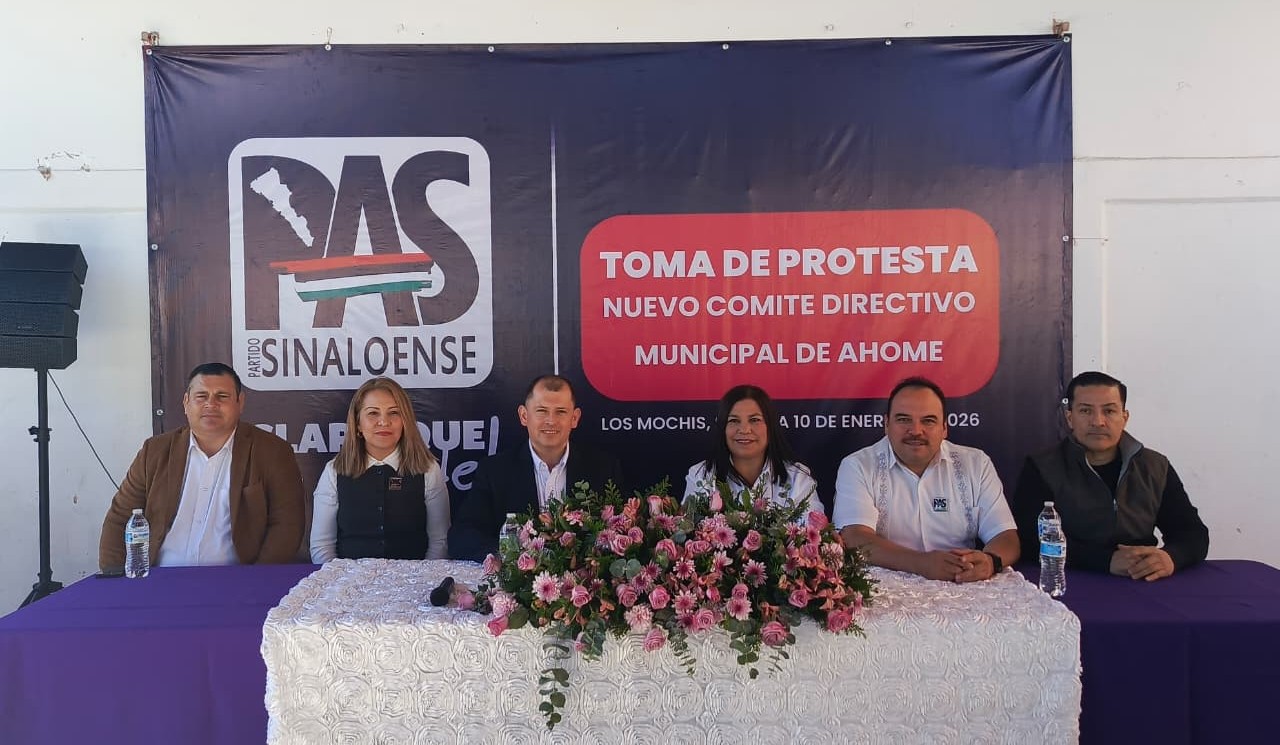 personas sentadas en una mesa en un evento de toma de protesta
