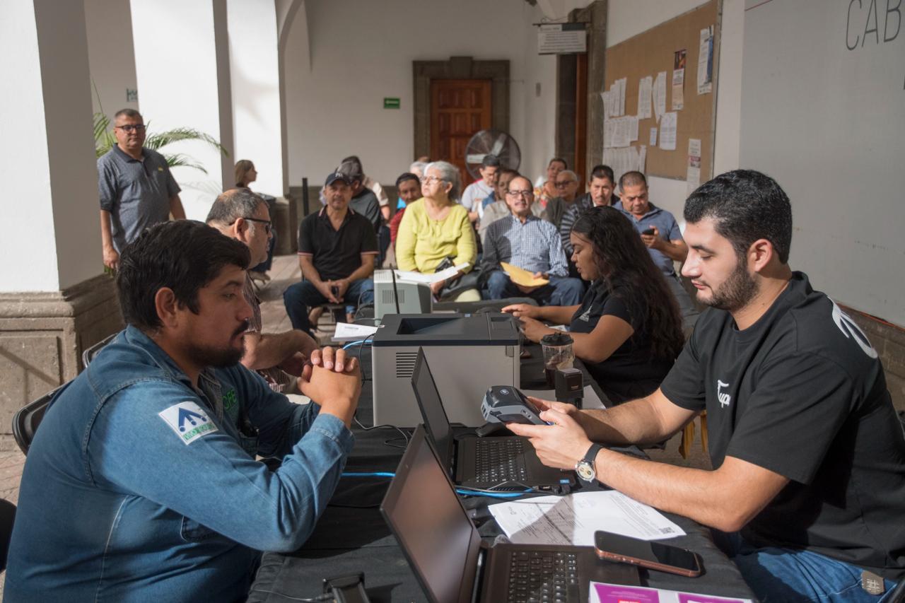 Personas con computadoras sentadas frente a otros
