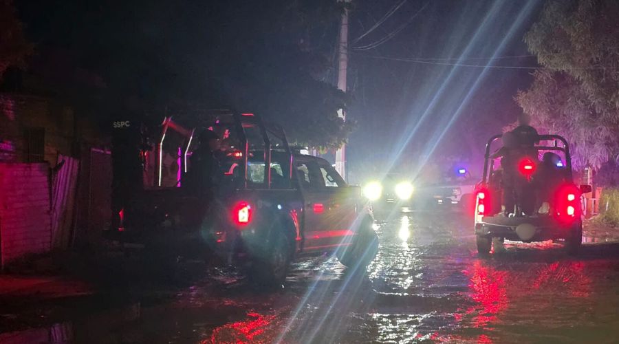 Unidades policiacas en un camino de terracería mojado por la lluvia
