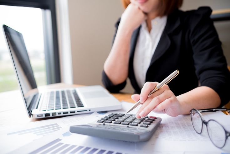 Persona con una calculadora y una laptop