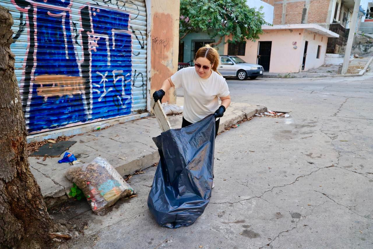 Señora junto a bolsa negra de la basura