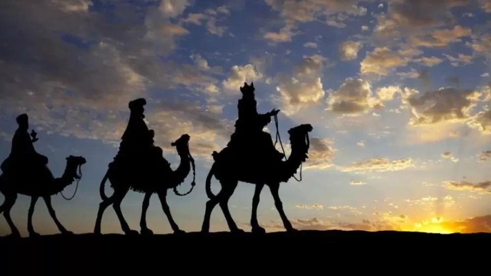 Imagen del cielo con nubes y la puesta de sol con sombras de los Reyes Magos en camellos