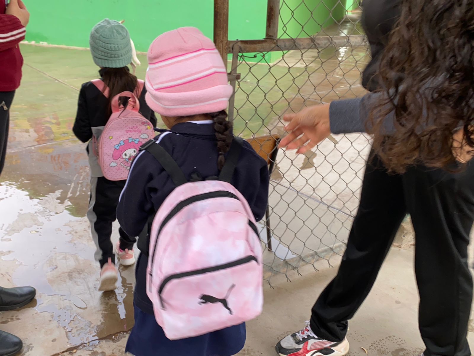 Niños de espaldas entrando a la escuela