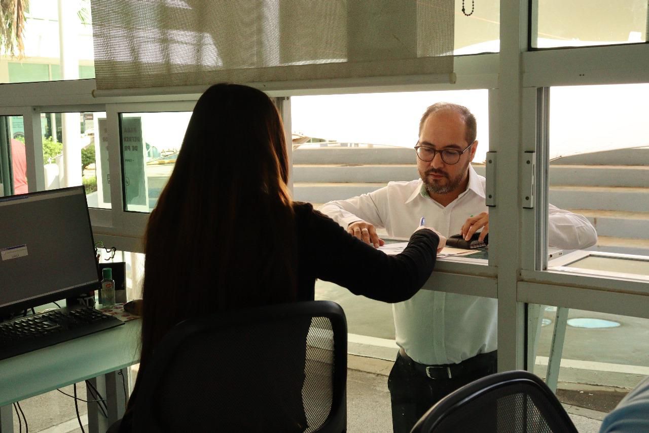 Persona realizando tramites en un modulo de sates y trabajadora atendiéndolo