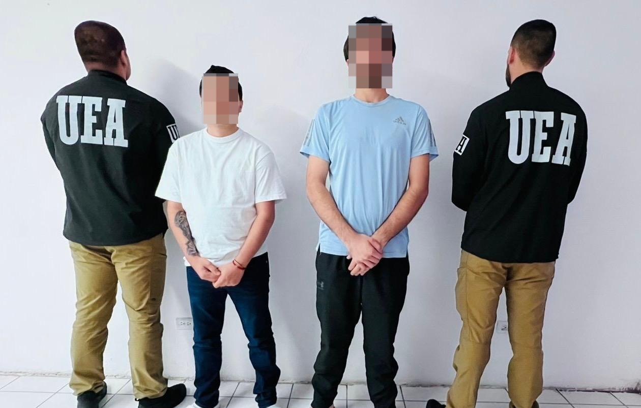Elementos de seguridad de espaldas y dos sujetos de frente con la cara pixelada