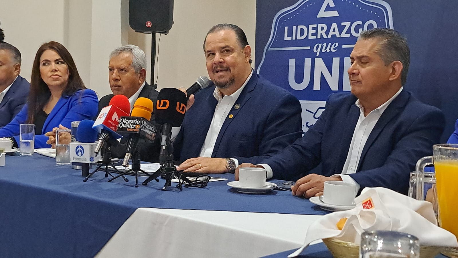 Personas en una mesa durante conferencia de prensa