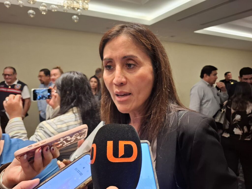 Mujer viendo hacia un lado con micrófonos frente a ella