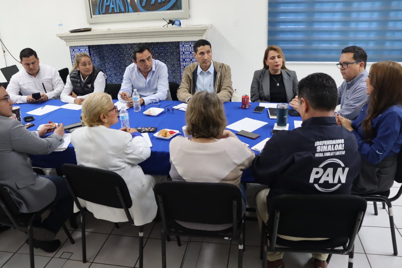 Regidores junto a directivos del pan en una mesa