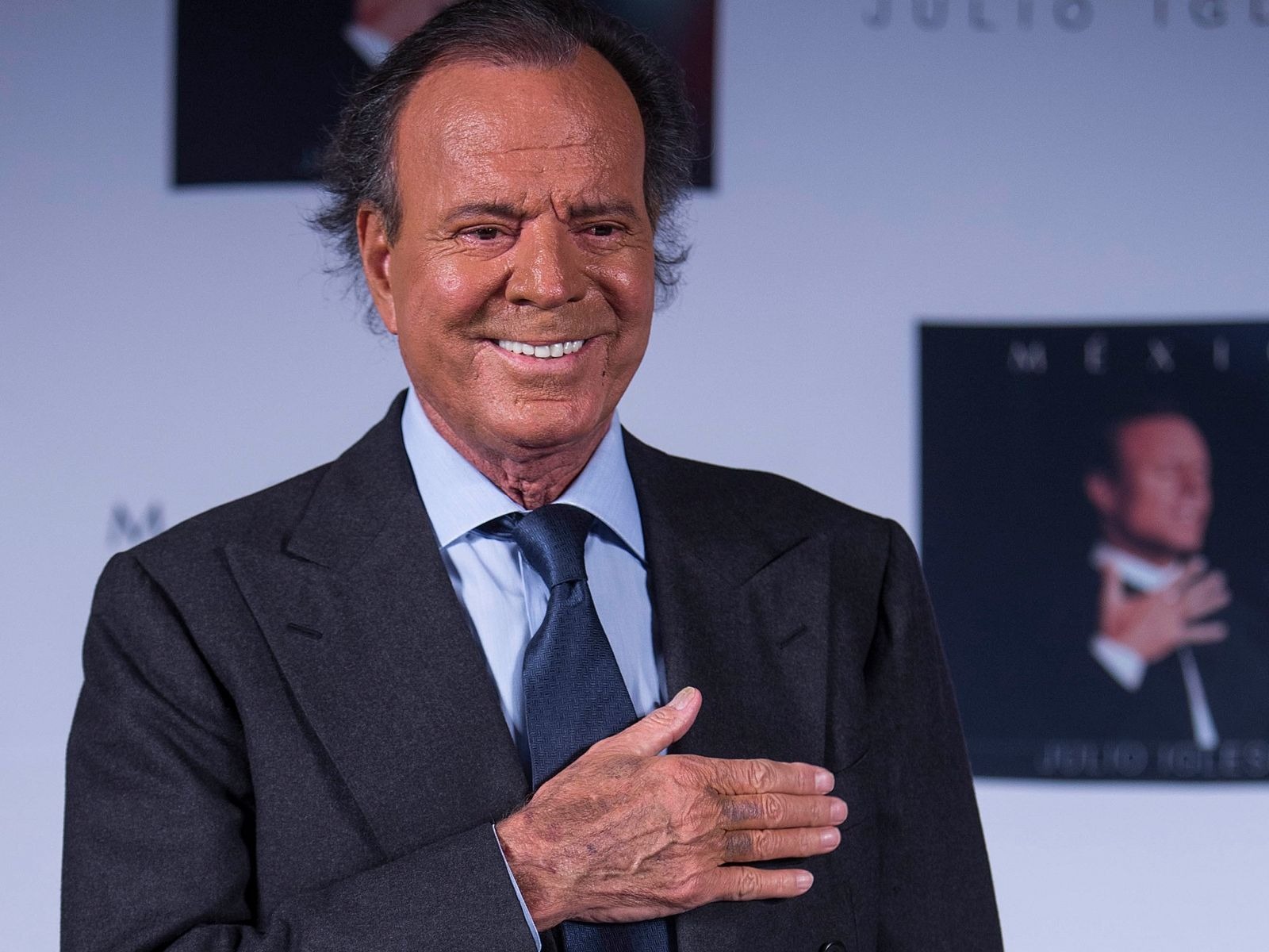 Julio iglesias con traje negro y sonrisa
