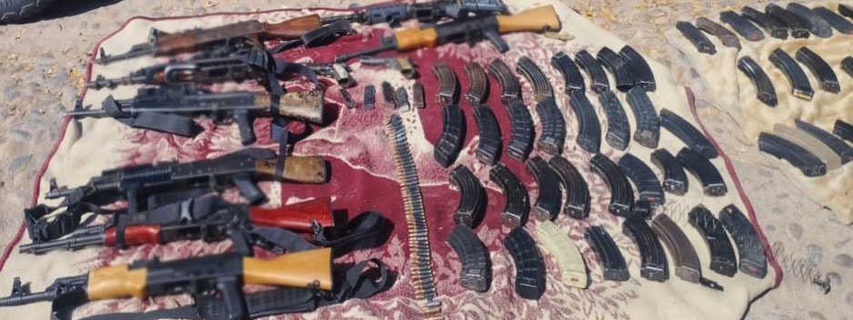 Armas y cartuchos sobre una lona en el suelo