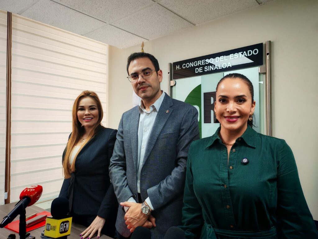 Tres personas de pie en una oficina viendo hacia el frente