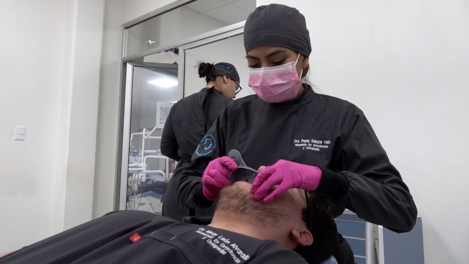 Persona realizando un proceso odontológico a otra persona en un consultorio de dentista