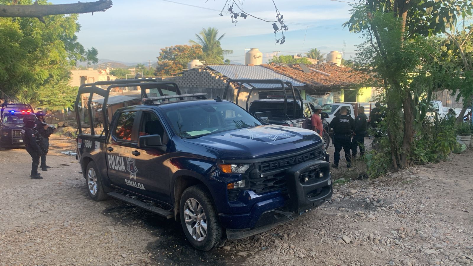 Unidades policiacas y elementos en un camino de terracería