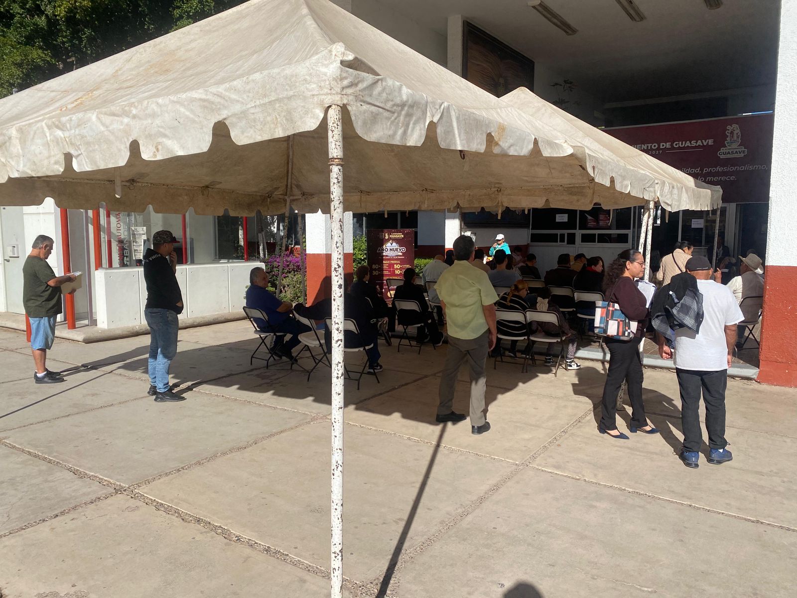 Personas abajo de una carpa afuera de un edificio