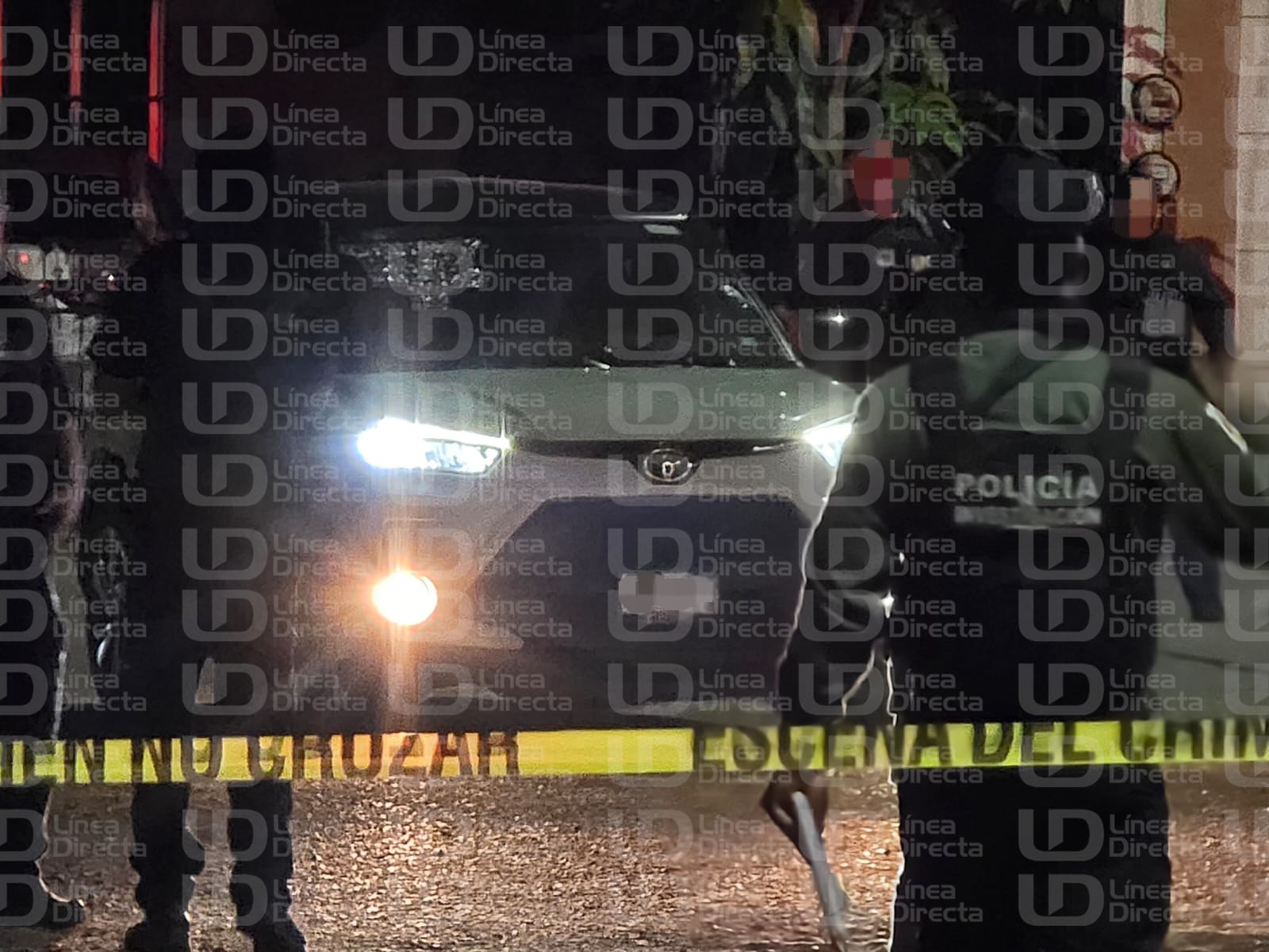 Elementos policiacos y una cintamarilla de precaución y un carro con las luces encendidas