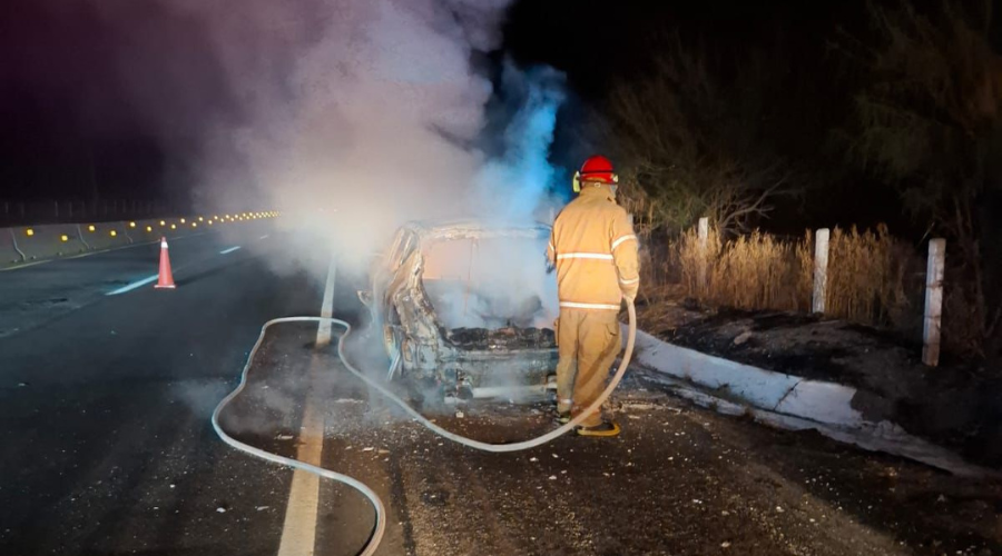 Bombero apaga el fuego sobre un vehículo