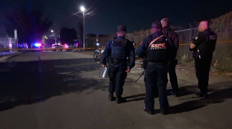 Personal de la SSPC en una calle junto a una cinta de precaución y al fondo unidades policiacas