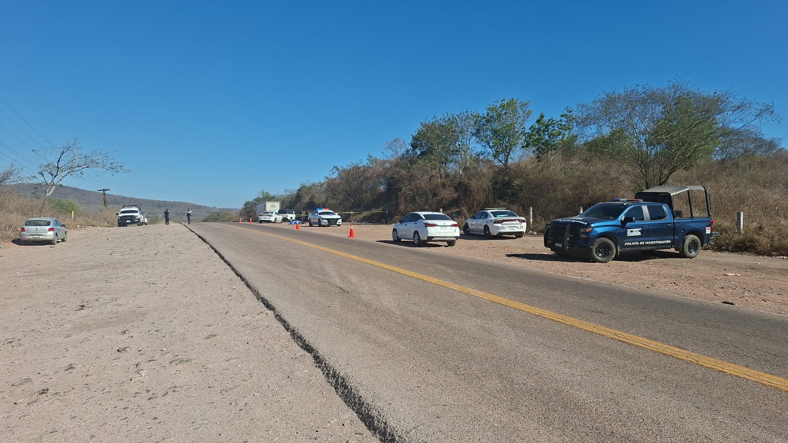 Elementos de seguridad estacionados en carretera en una zona acordonada