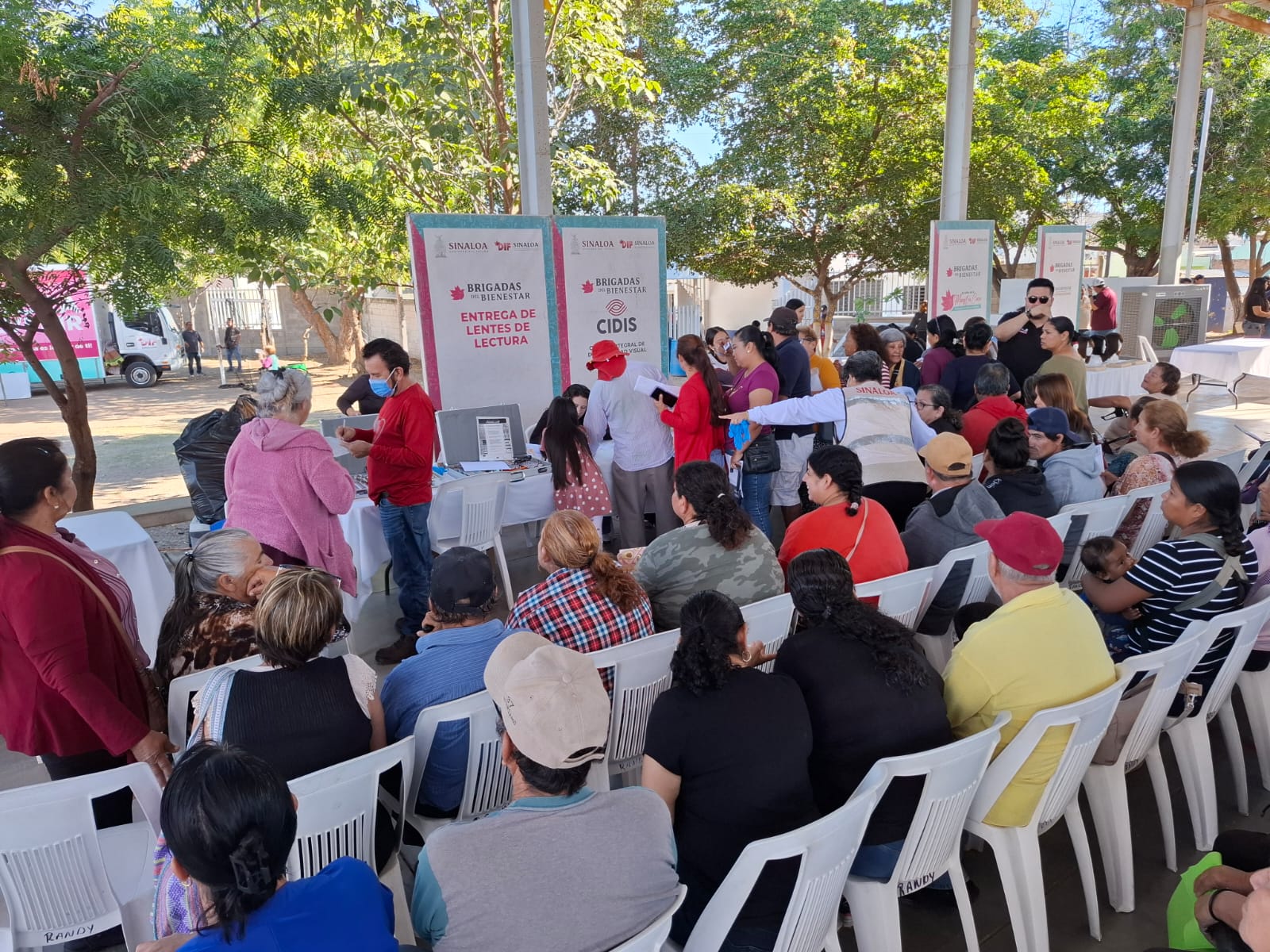 Personas siendo atendidas y otras sentadas durante brigada