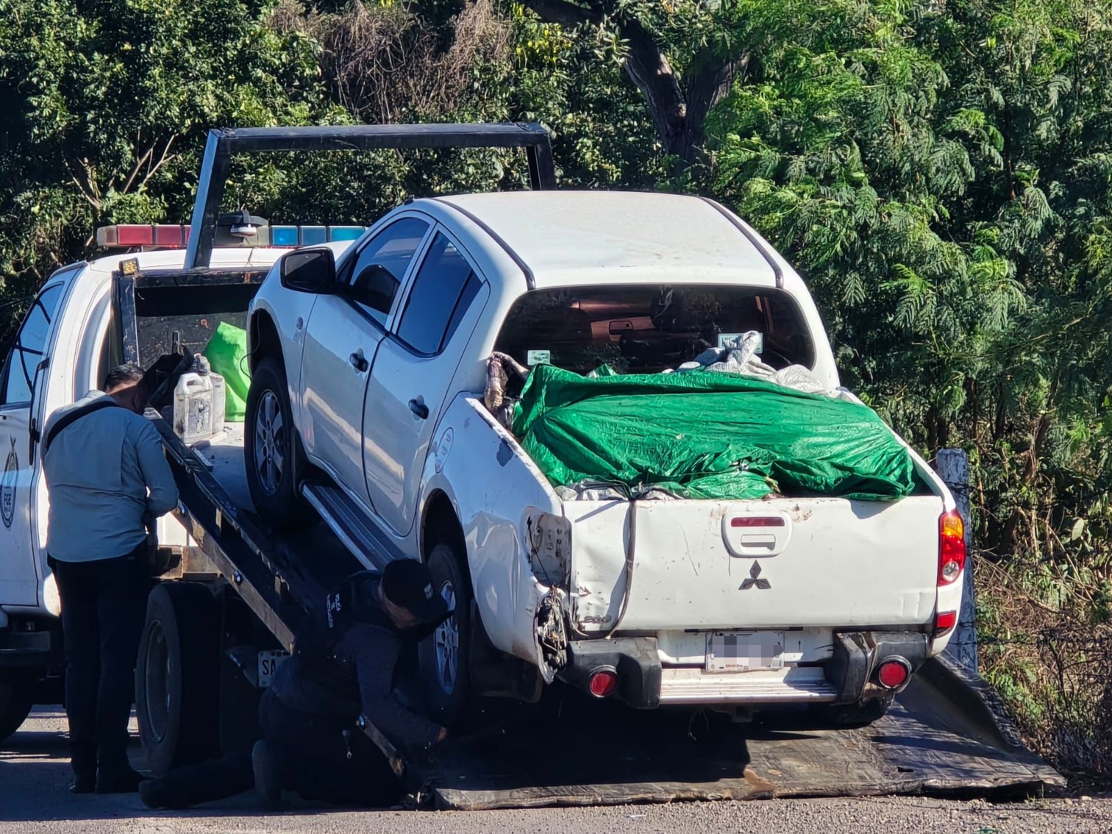 Camioneta abandonada con personas sin vida.