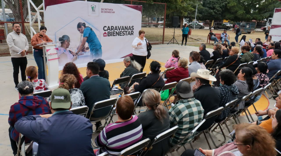 Personas sentadas, en campaña de caravanas del bienestar