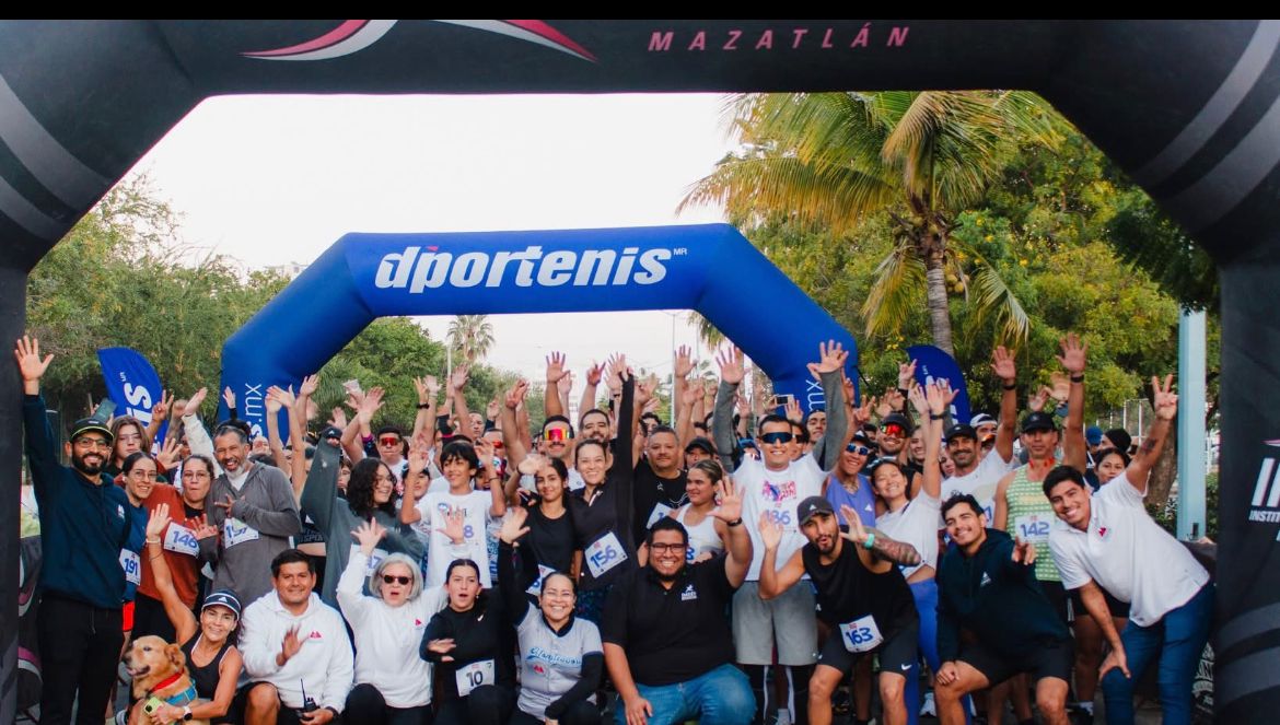 Gran grupo de corredores posando para la foto en la meta