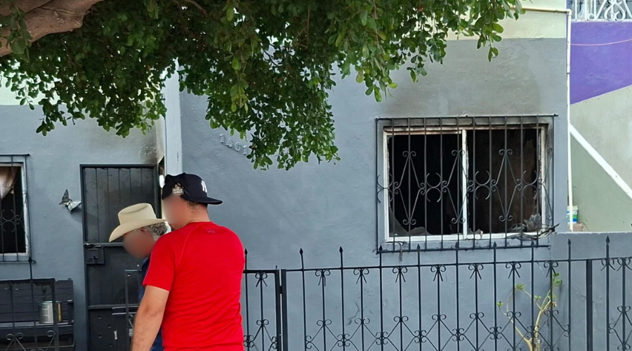 Casa incendiada y personas pasando por el domicilio