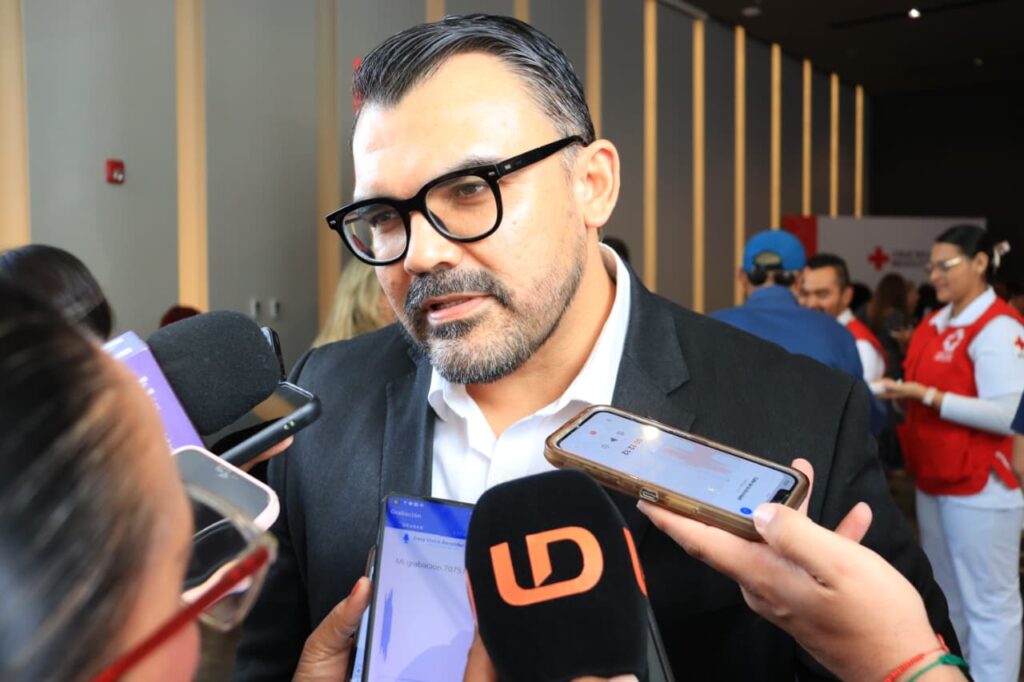 Persona con micrófonos y celulares frente a él