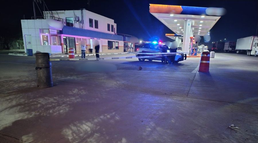 unidad policiaca en una estación de servicio junto a una cinta amarilla de precaución
