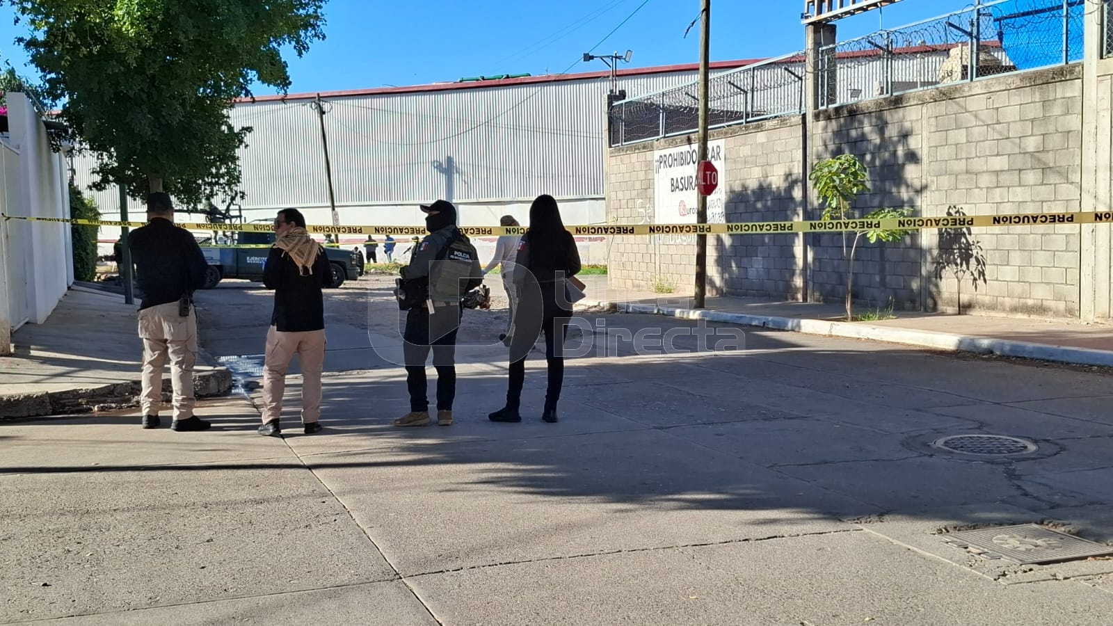 Elementos policiacos junto a una cinta amarilla de precaución en una calle